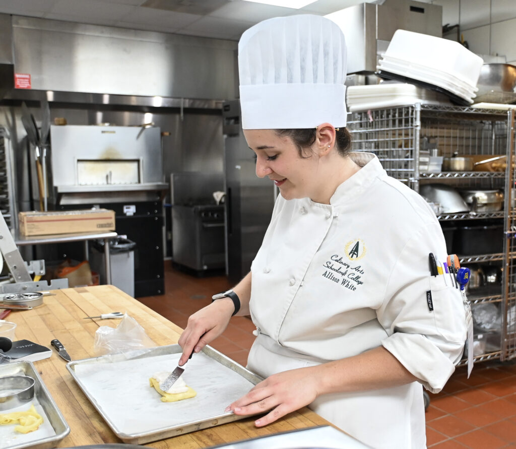 chef glazing pastry in kitchen