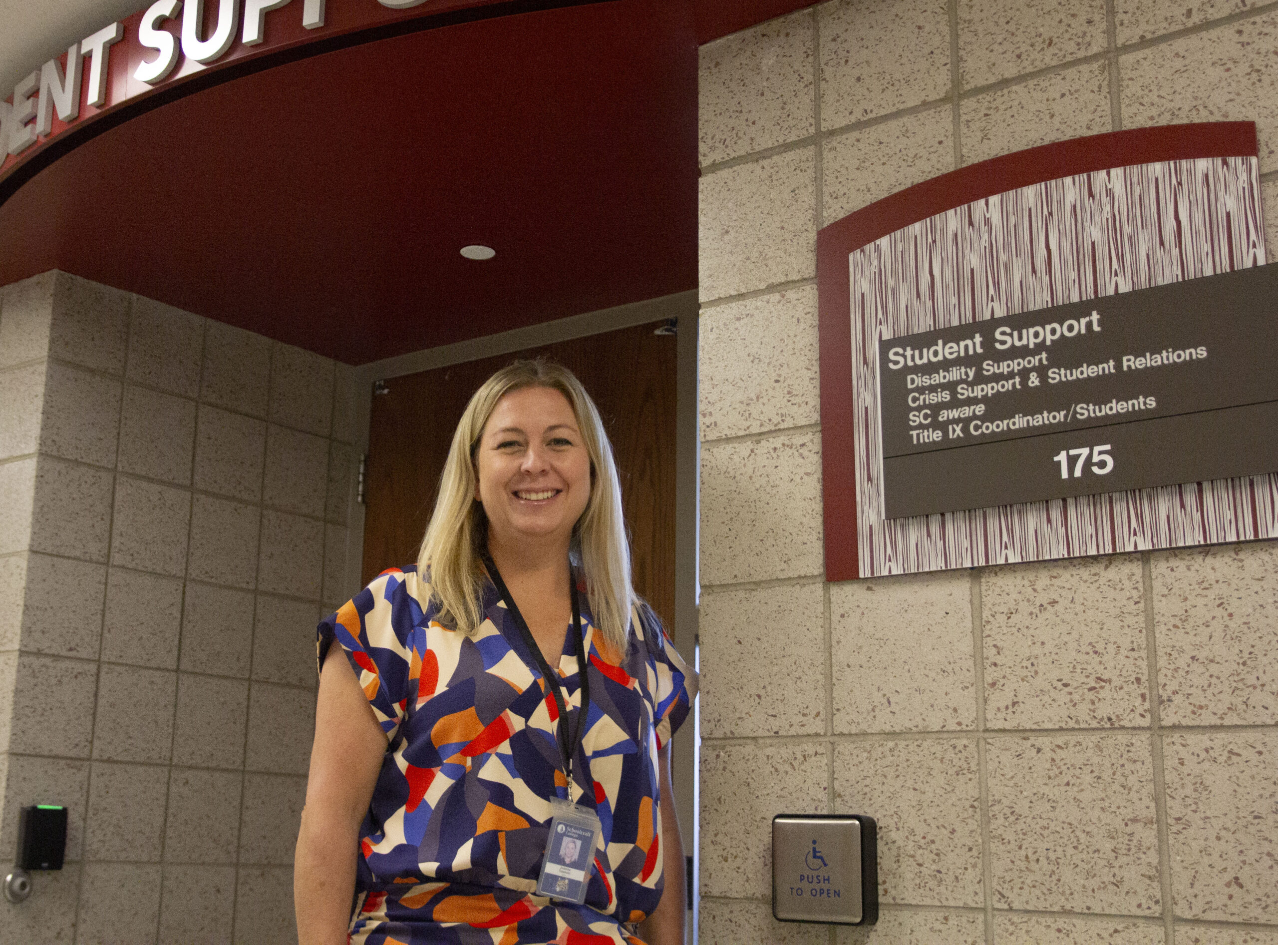 person smiling outside department hallway doors
