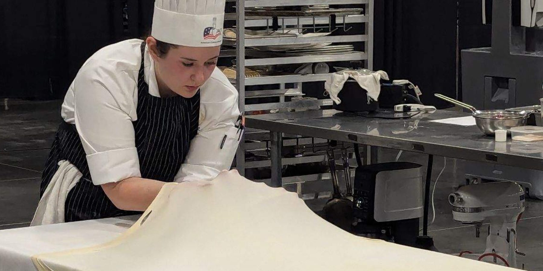 student chef stretching dough