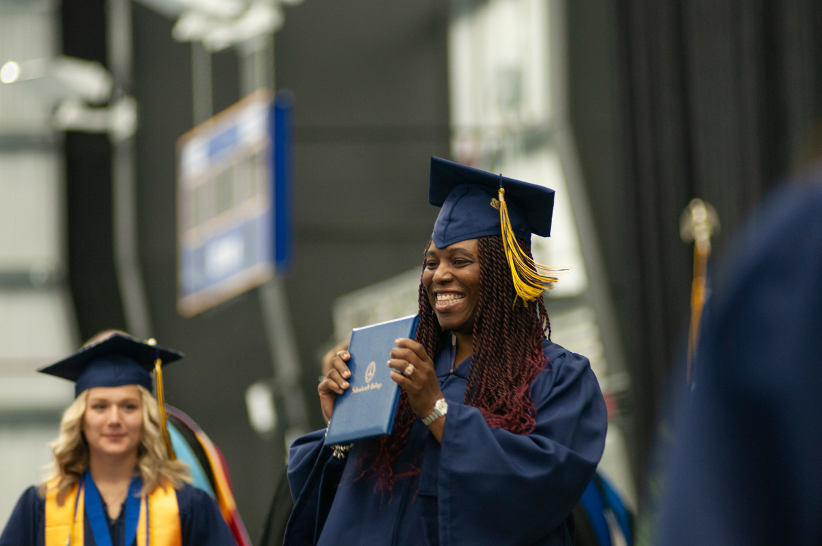 graduate holding her diploma