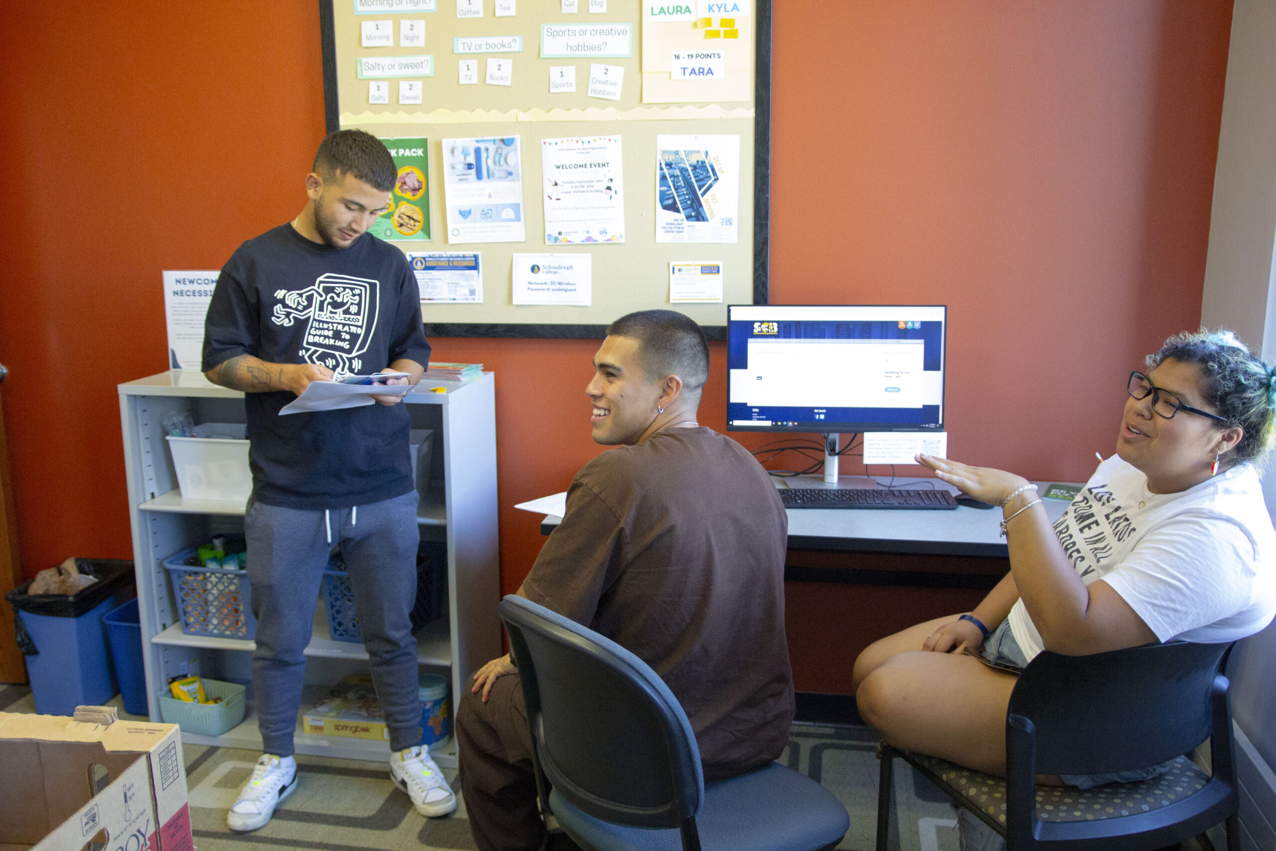 students conversing around a computer
