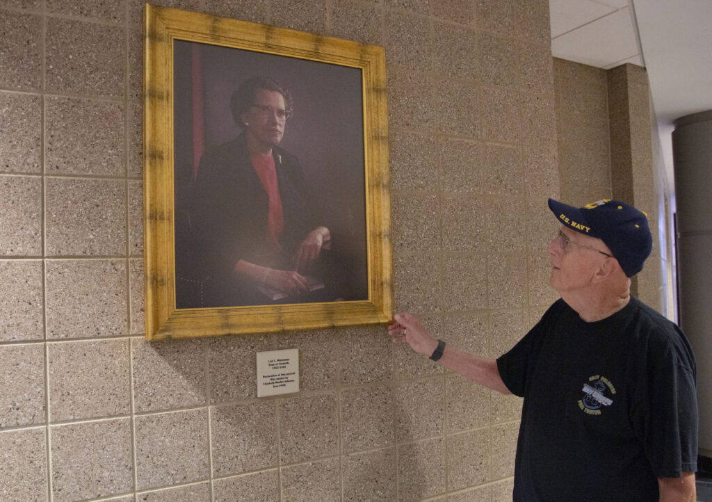 Person observing wall artwork