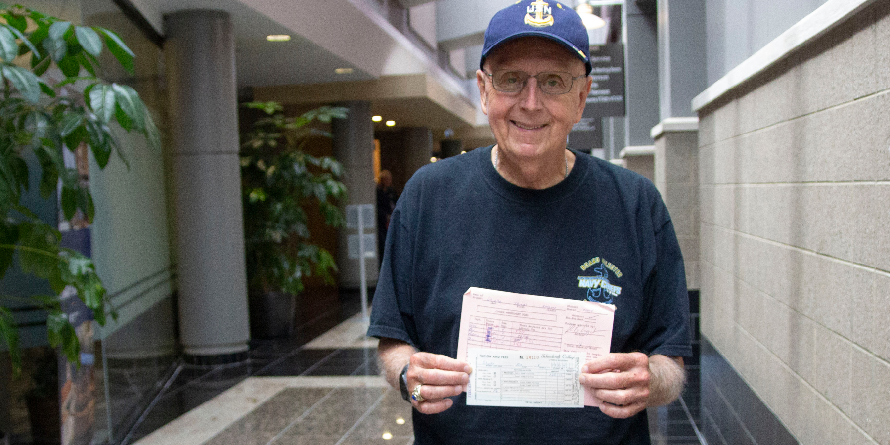Tom Shipley holding old papers in hallway