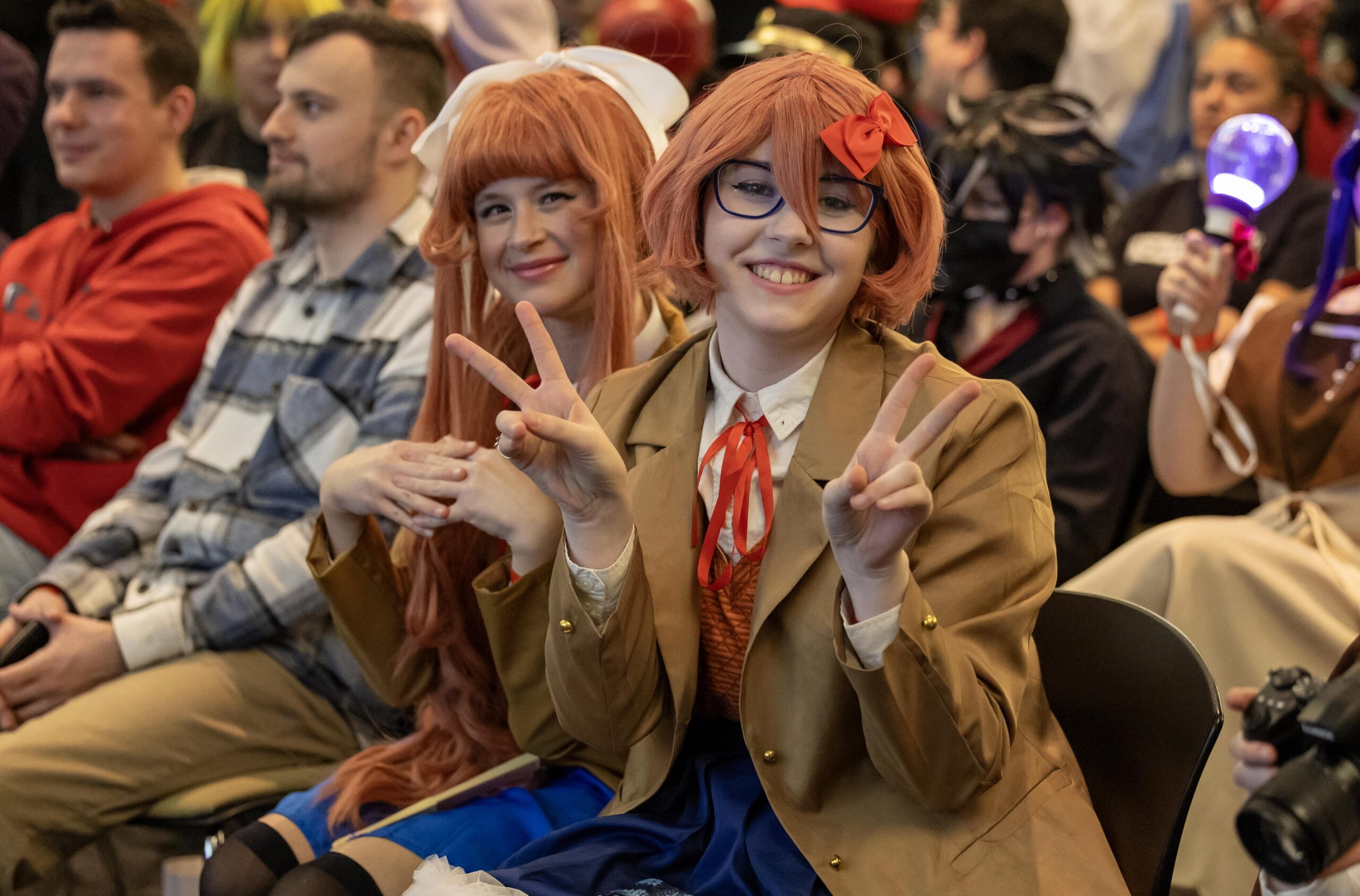 two people smiling with peace sign in pose