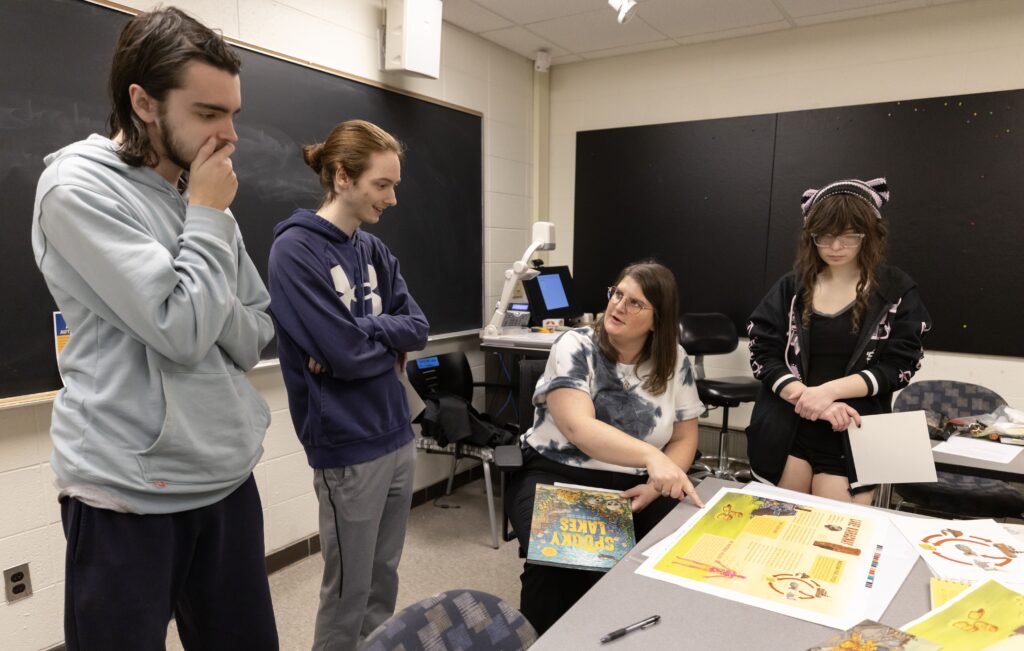 students reviewing booklet pages in print