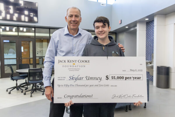 student holding large $50,000 check