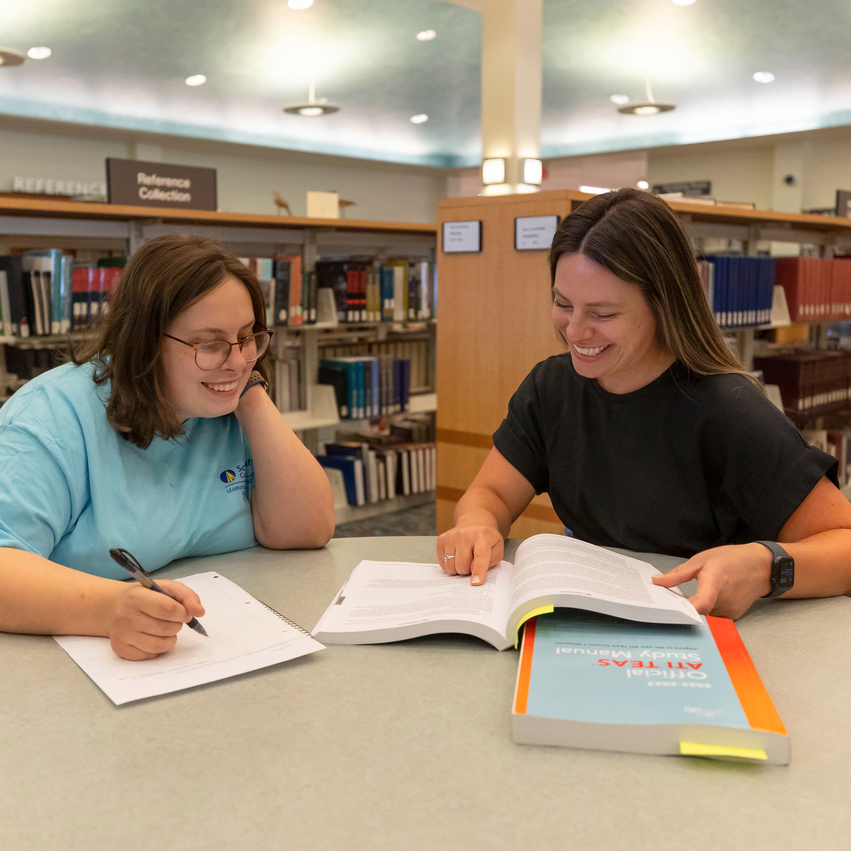 Campus_Life_Bradner_Library_003 square two people reviewing books in library