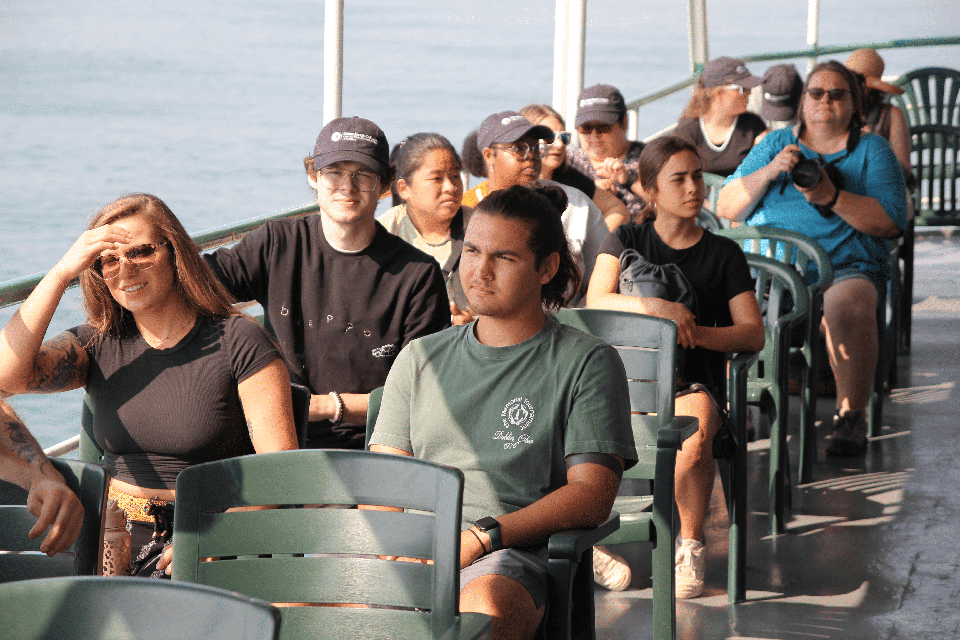 students sitting and riding a large boat