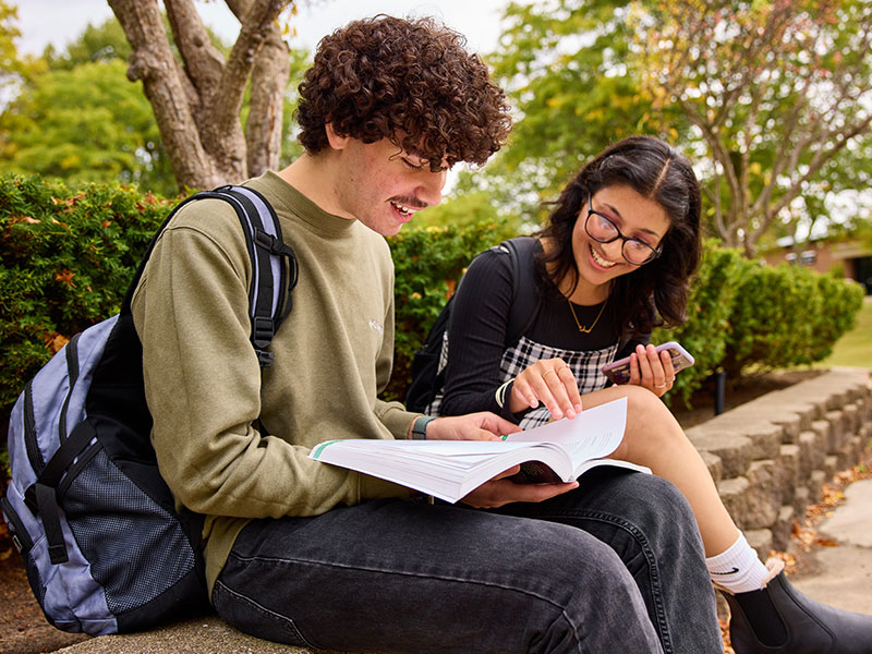 Schoolcraft Homeschool Night - Two students sitting outside reading