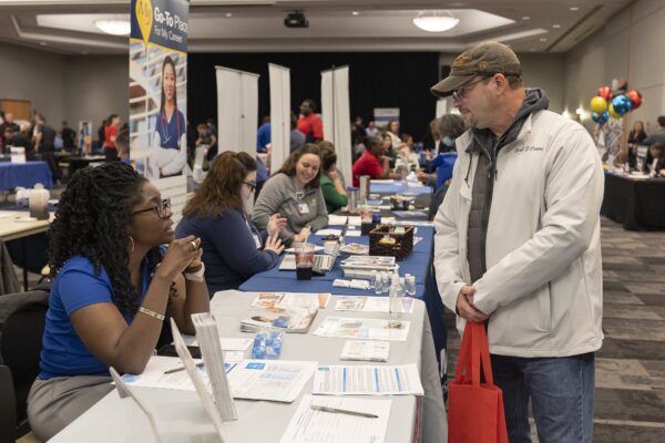 people talking at exhibit table