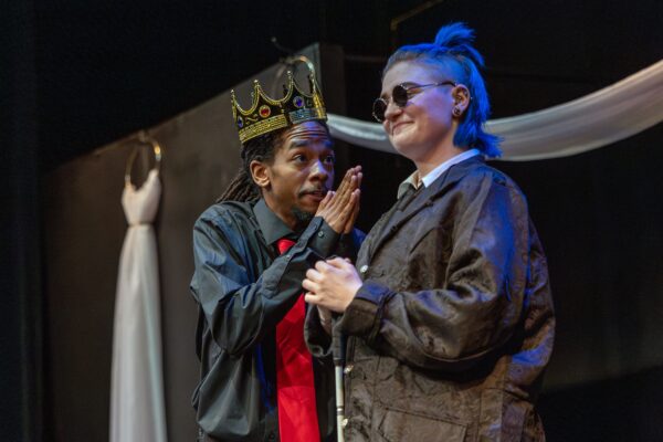 king actor speaking to another actor on stage