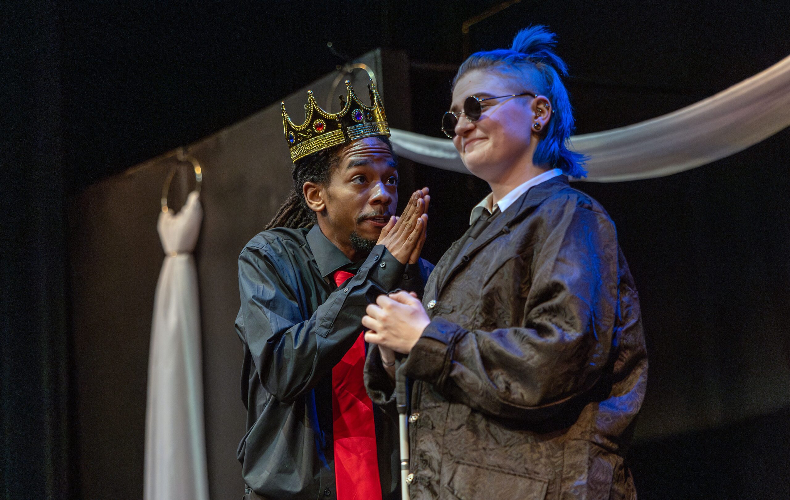 king actor speaking to another actor on stage