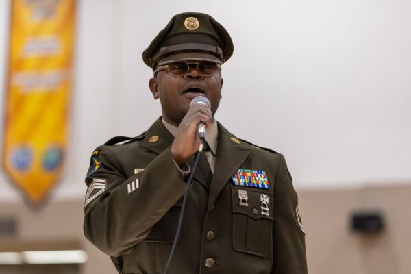 Michigan Army National Guard Sgt. 1st Class Tim Brown singing with mic