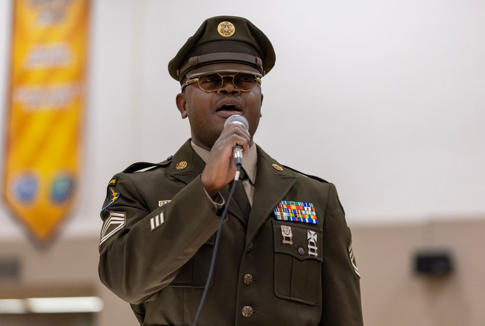 Michigan Army National Guard Sgt. 1st Class Tim Brown singing with mic