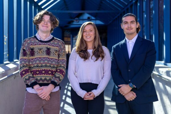 three students under awning outdoors