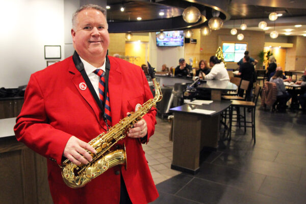 person in red suit holding saxaphone