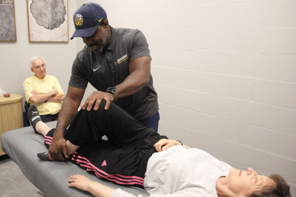 person practicing knee movement with patient