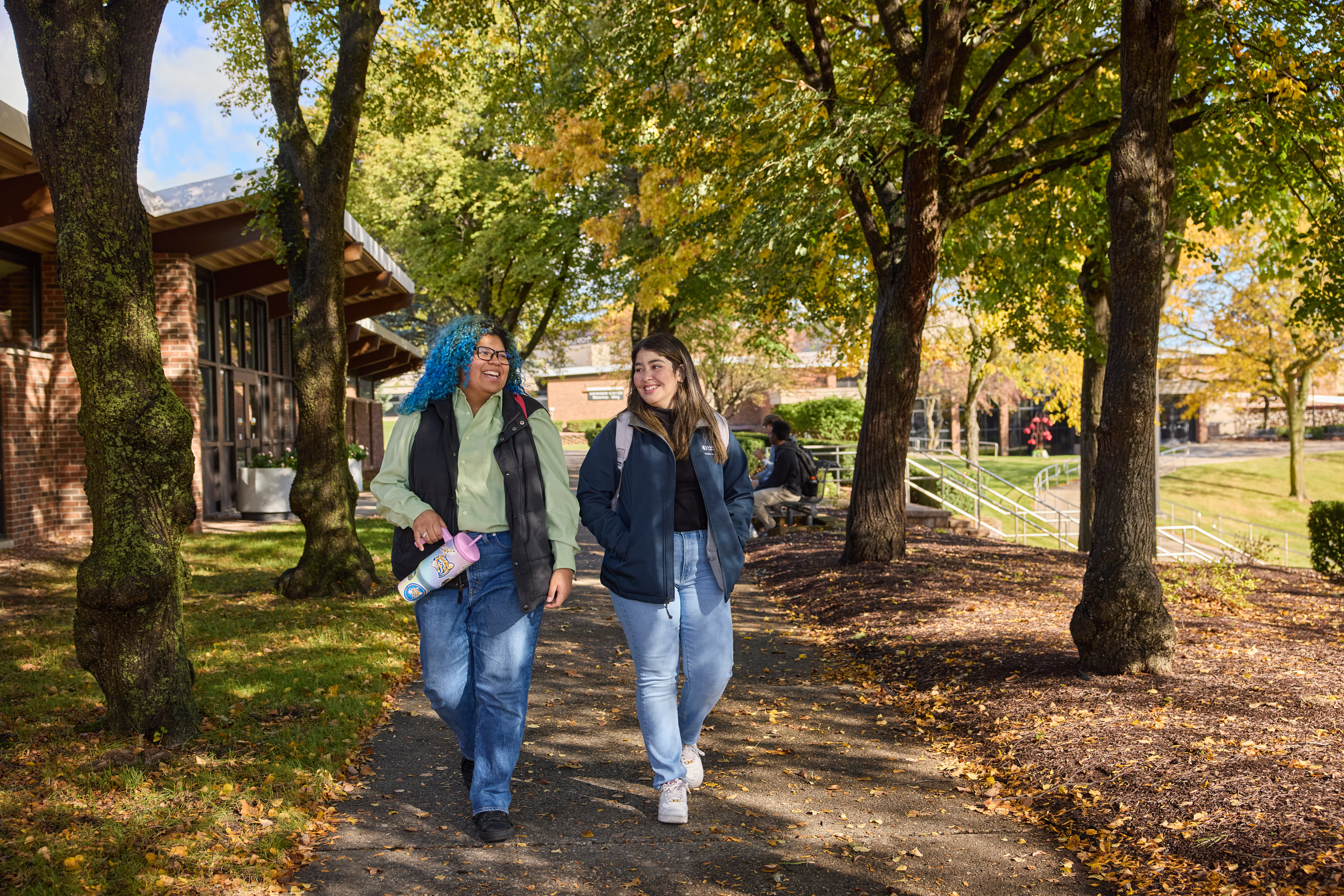 students walking outdoors campus in fall