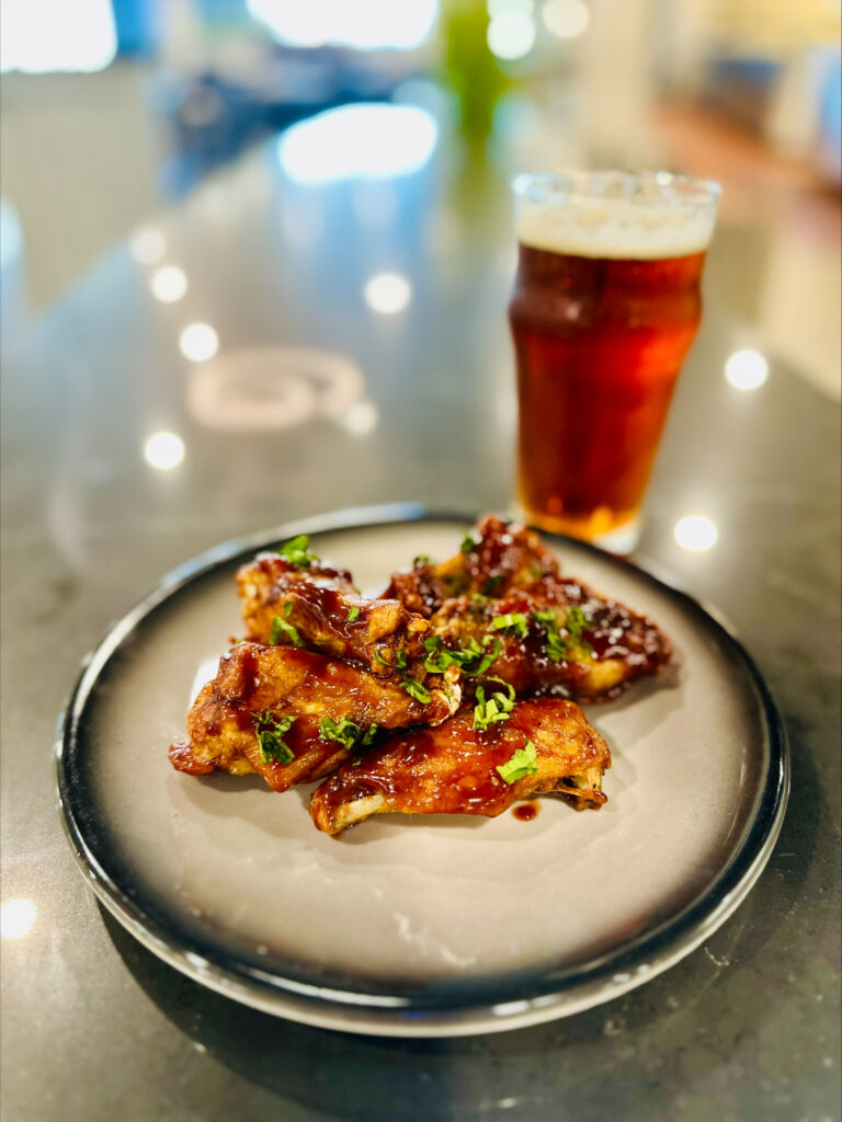 meal display of chicken wings and beer