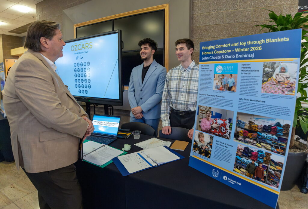 students talking at exhibit table