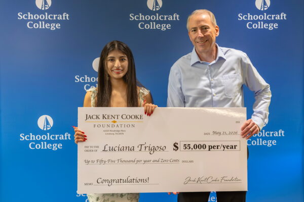 student and president holding large $50k check
