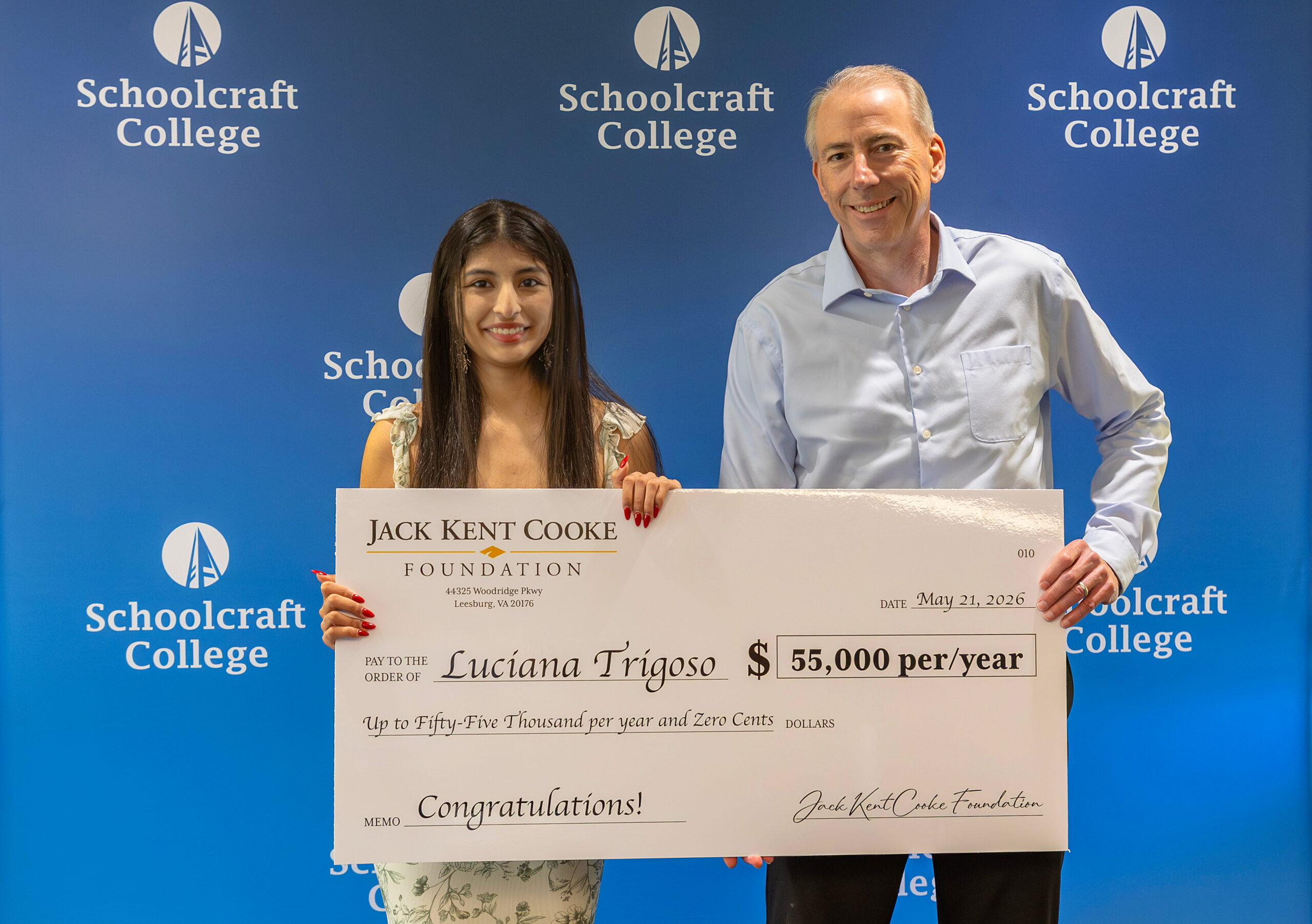 student and president holding large $50k check