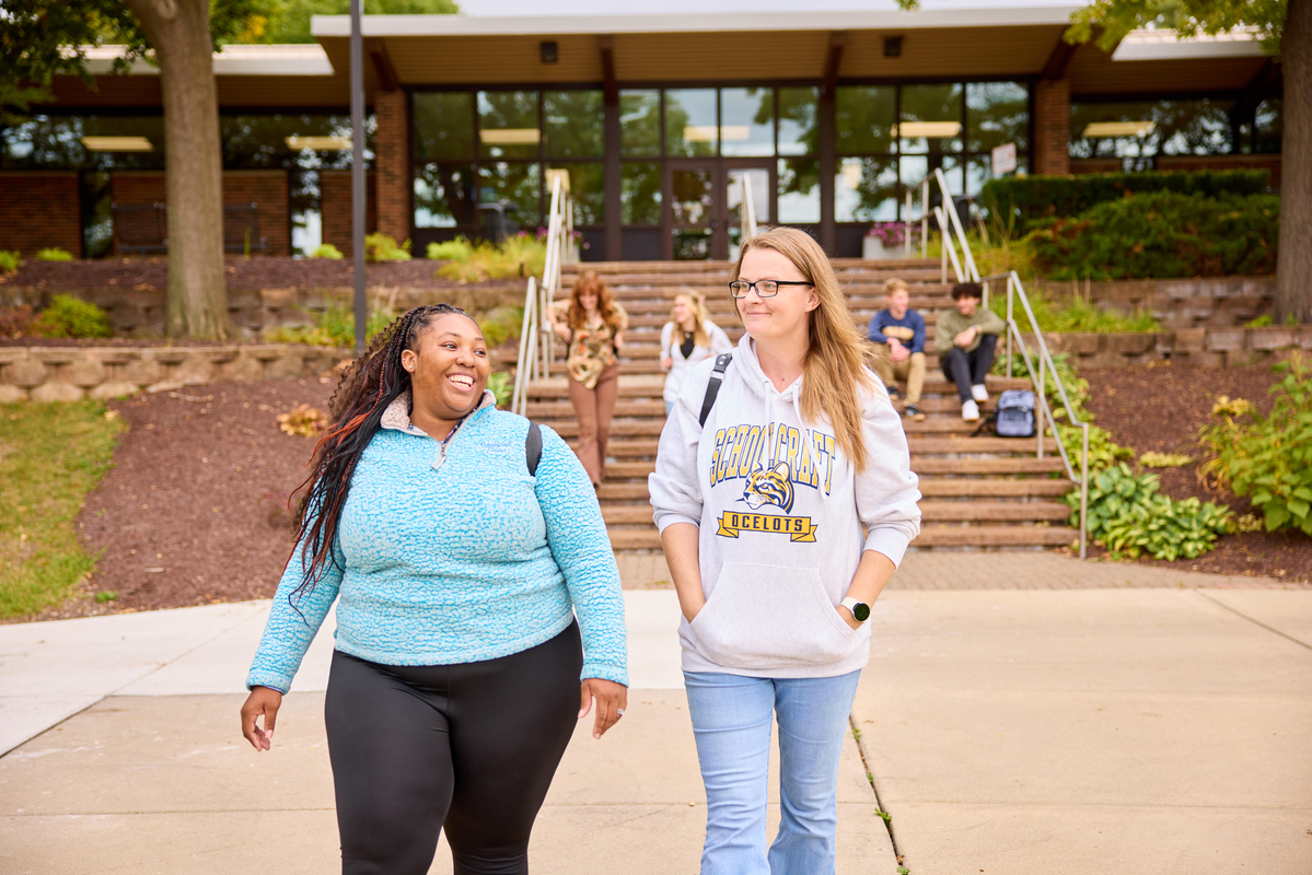 two women walking around campus