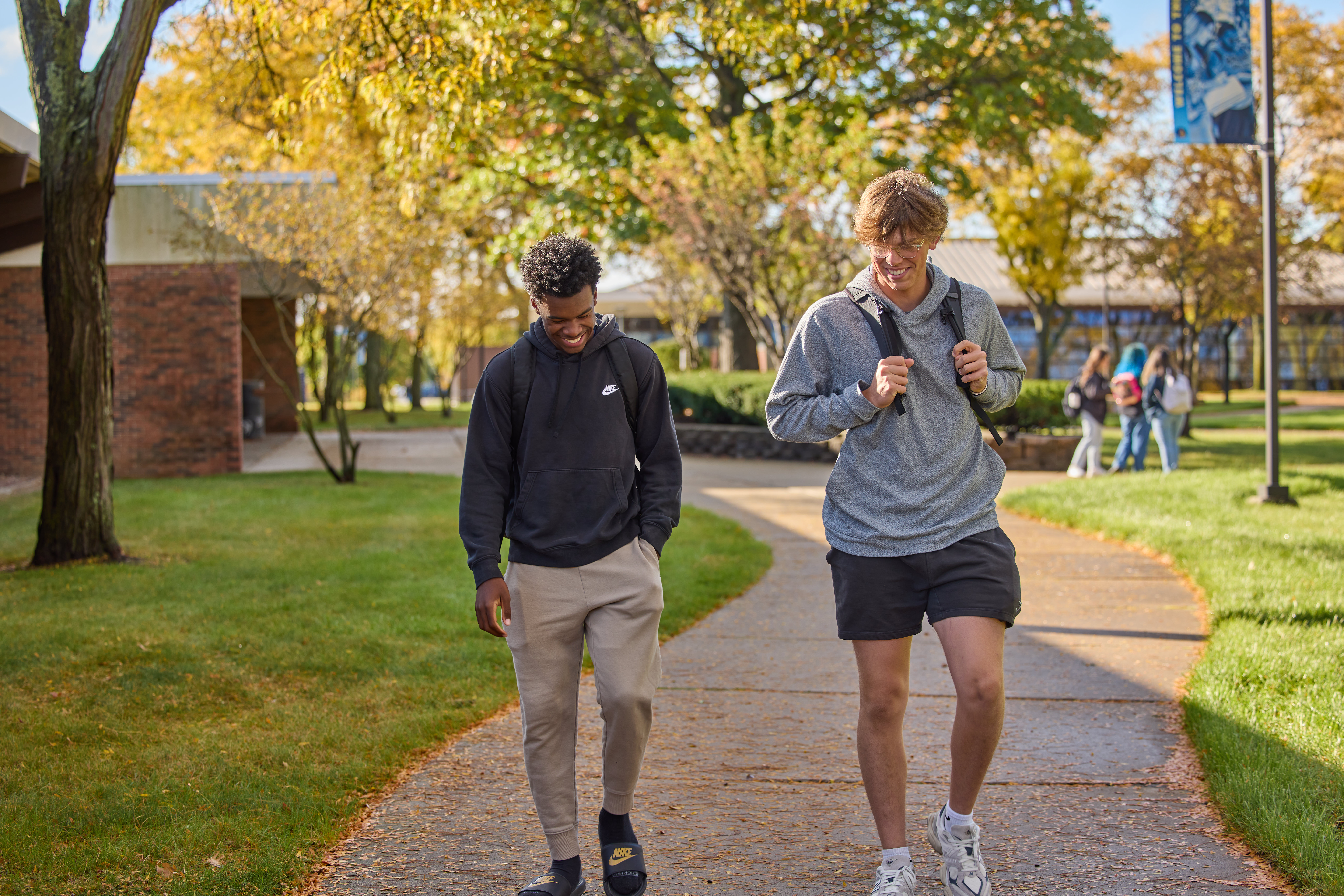 two students walking on the sidewalk