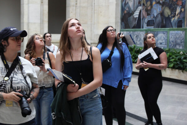 students looking up at the mural on the wall