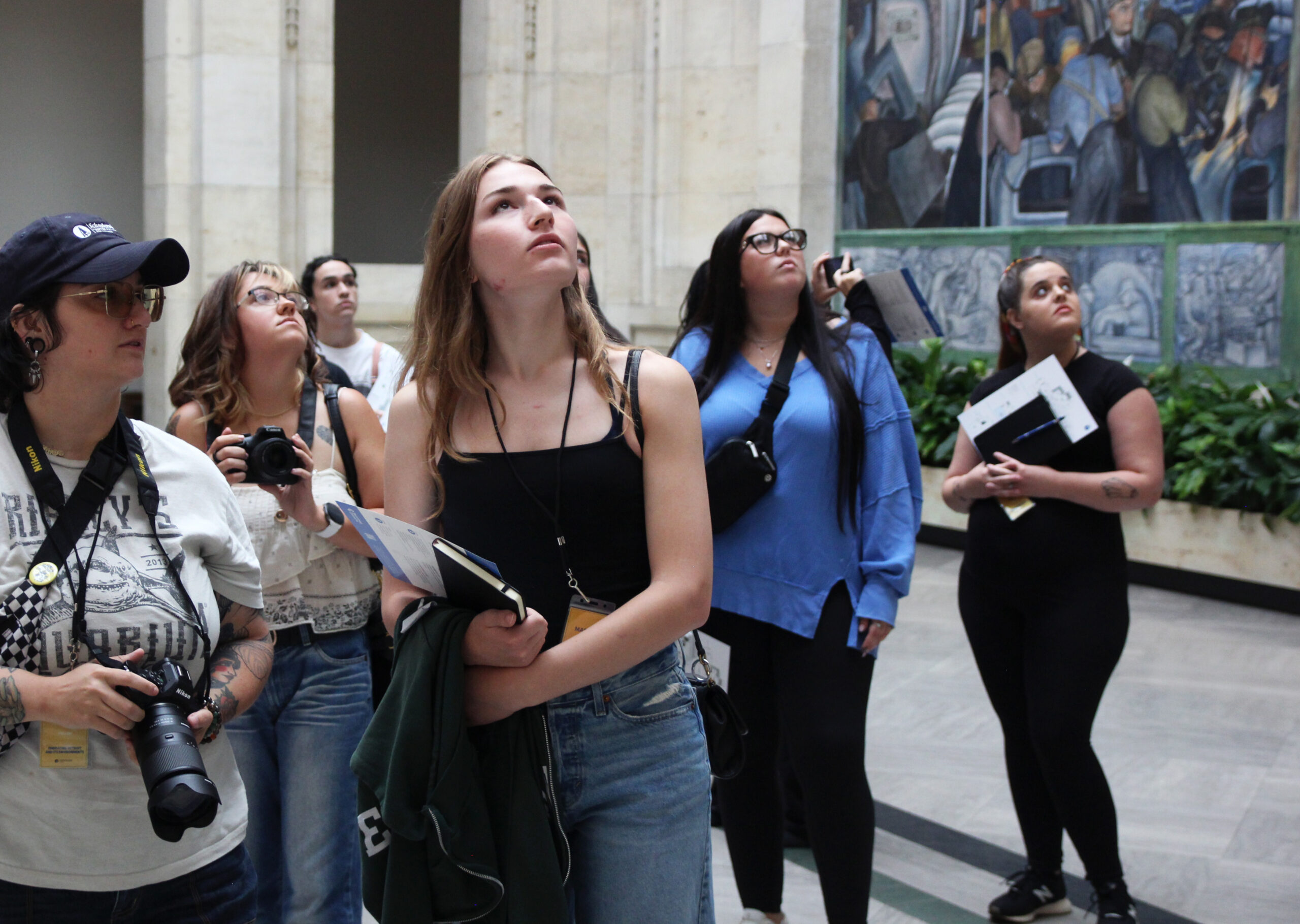 students looking up at the mural on the wall