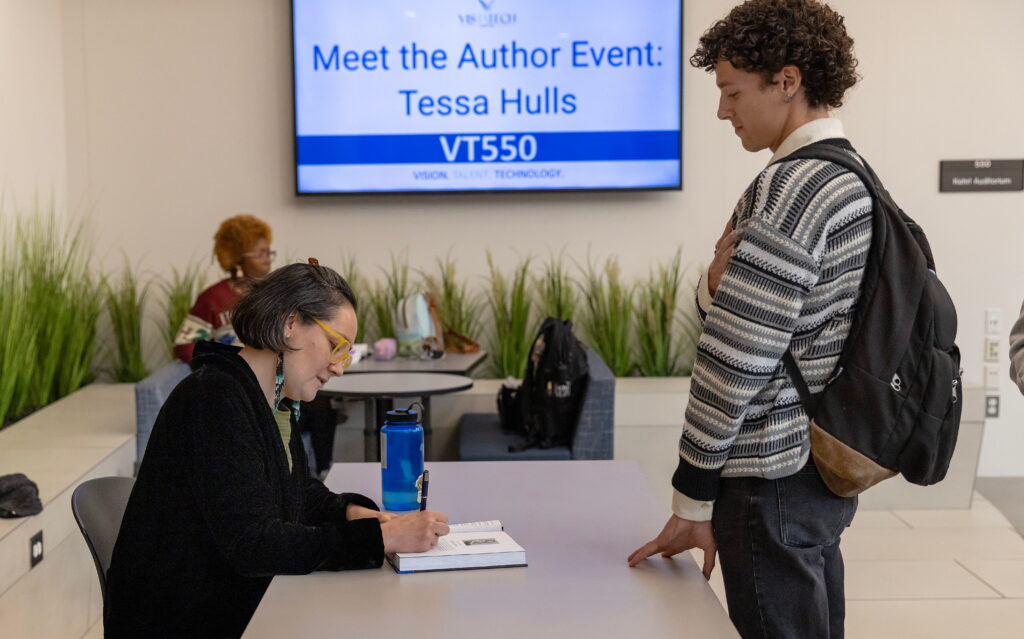 author signing book for guest